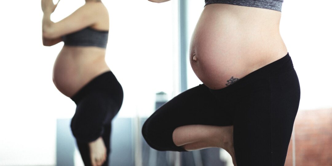 Two women practicing prenatal yoga in tree pose