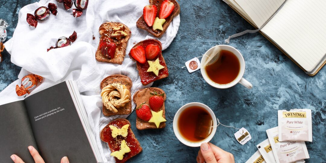 person holding ceramic tea cup filled with brown tea