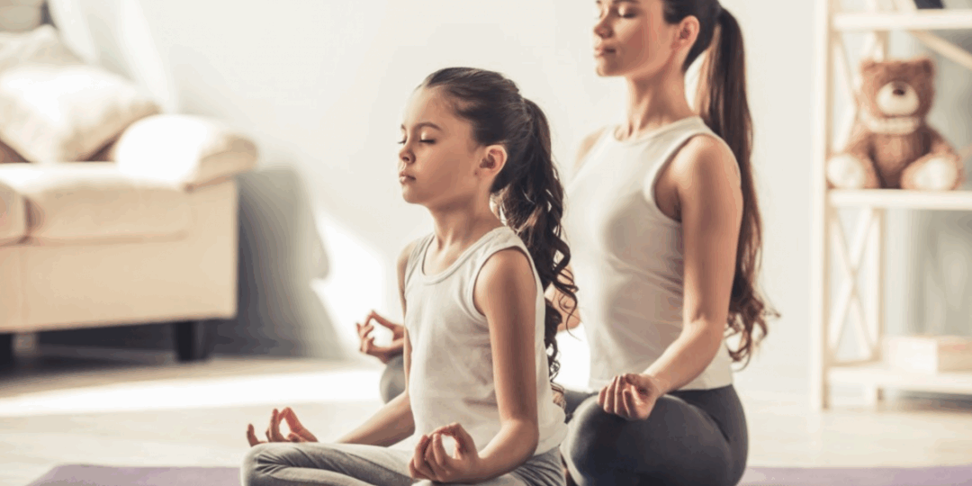 Mother and Daughter meditating on yoga mats