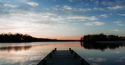 dock on lack at sunrise with forest in background