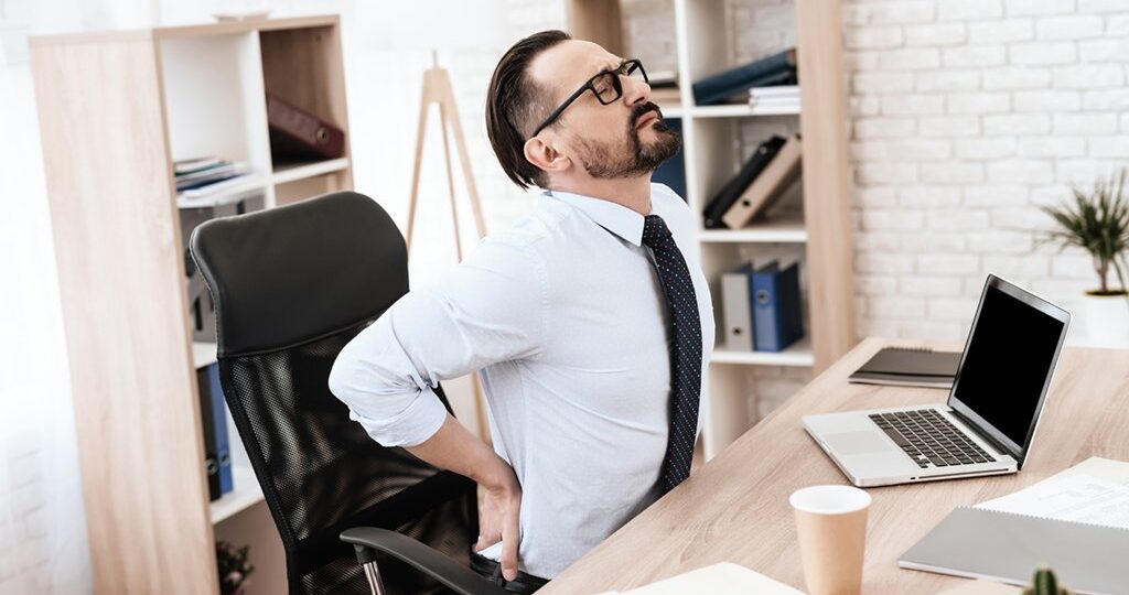 man sitting at desk with back pain